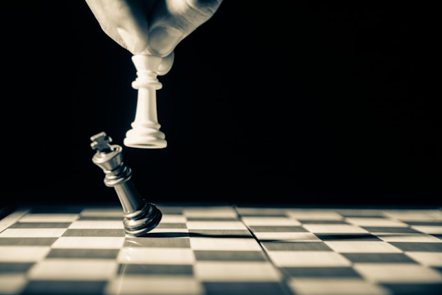 white chess piece knocking off black piece