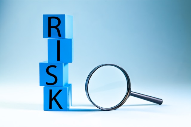 Blue blocks spelling out Risk and with a magnifying glass next to it