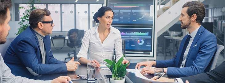 executives and engineers in a conference room reviewing data