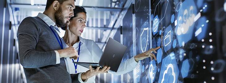 Male IT Specialist Holds Laptop and Discusses Work with Female Server Technician in a server room