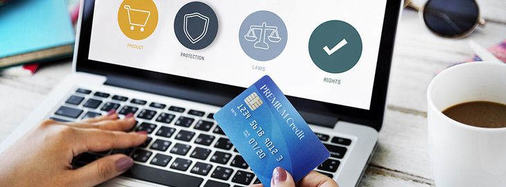 female holding credit card while typing on keyboard